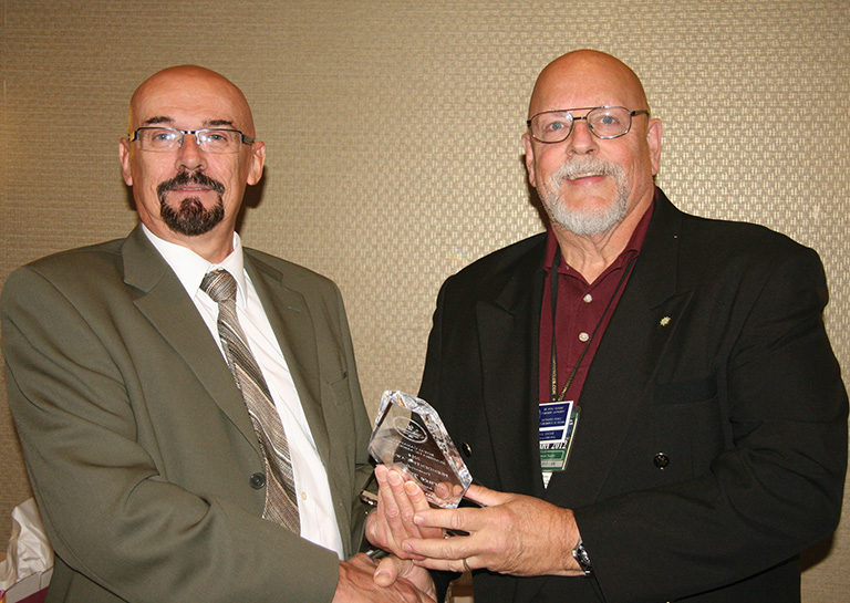 Bruce Taylor receiving his presidential award from RCNA
						President Bret Evans